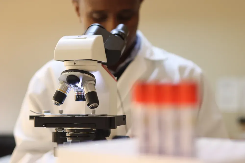 A laboratory scientist working at a microscope